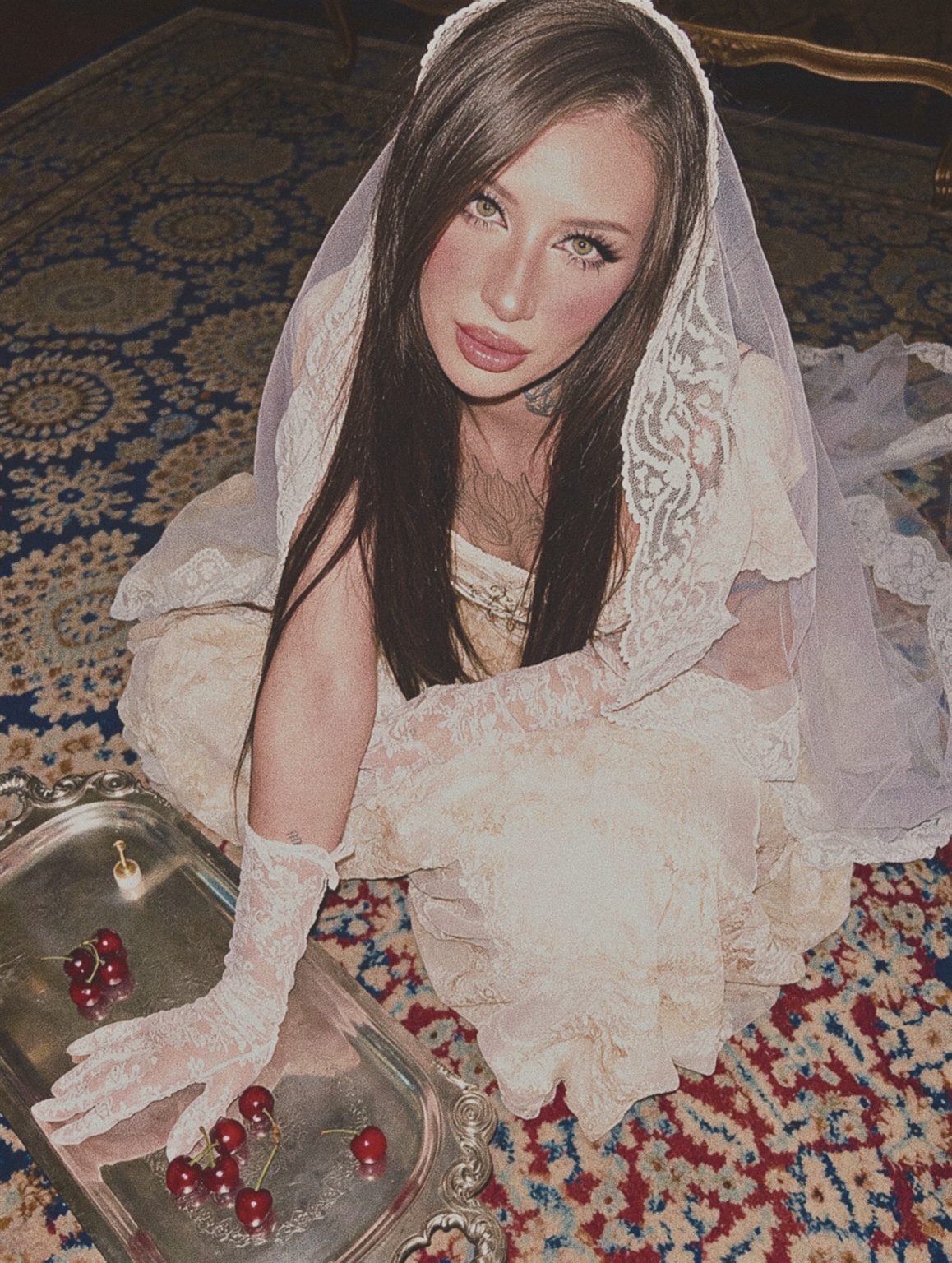 Juliette in ivory lace beside a silver tray of cherries